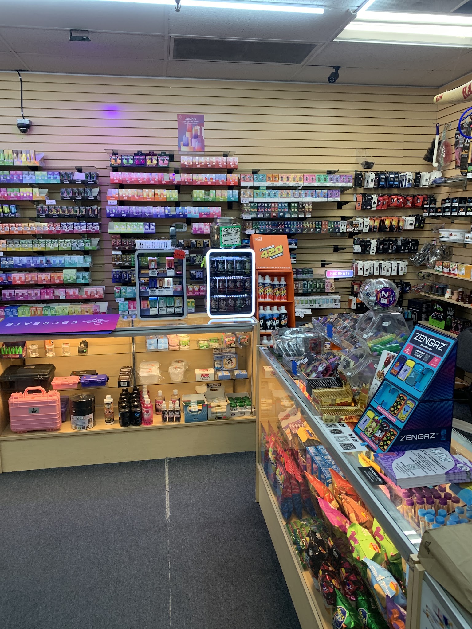 Shelves of smoke shop products and a glass display counter